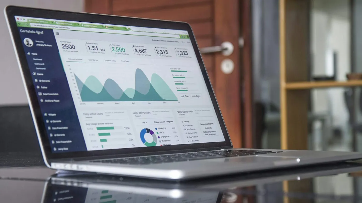 Laptop showing website analytics on a glass table